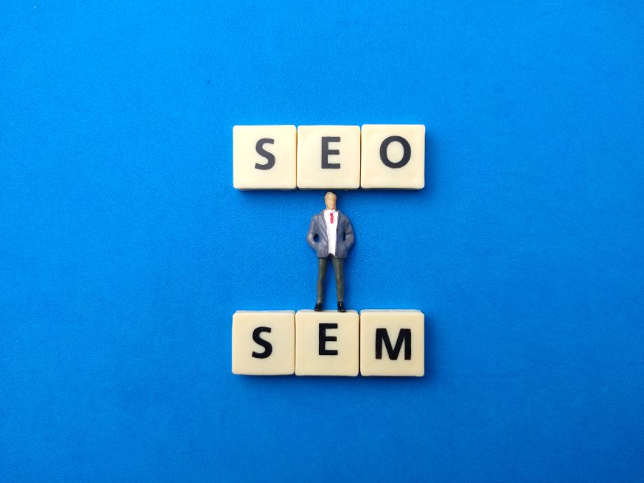 Top view miniature people and toye word with text SEO SEM on blue background