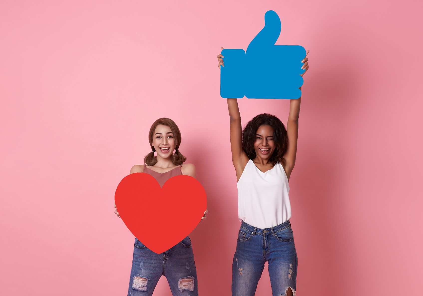 couple woman cheerful smile showing red heart with like Facebook icon symbol on pink studio background