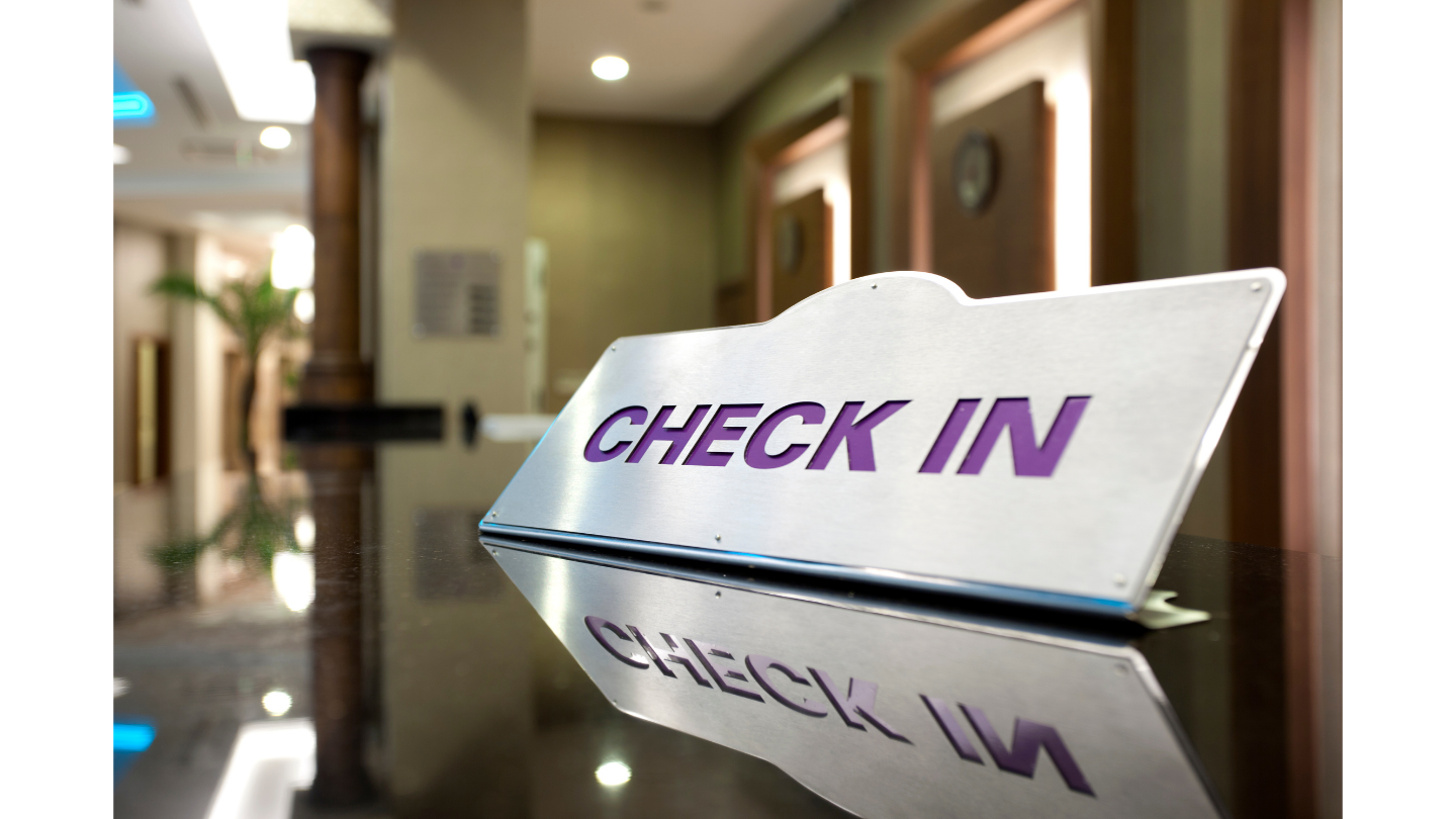 Check-in sign at conference reception desk for instant badge printing and fast attendee registration at an international conference.
