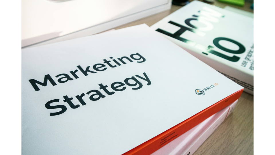 Close-up of a 'Marketing Strategy' book, visualizing data-driven marketing approaches that let data lead the way instead of guessing.