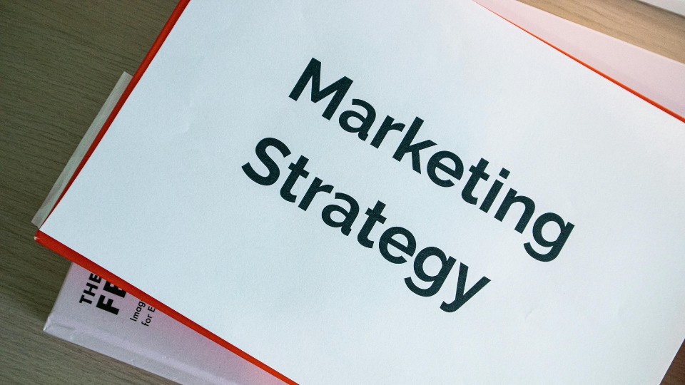 Close-up of a 'Marketing Strategy' book, visualizing data-driven marketing approaches that let data lead the way instead of guessing.