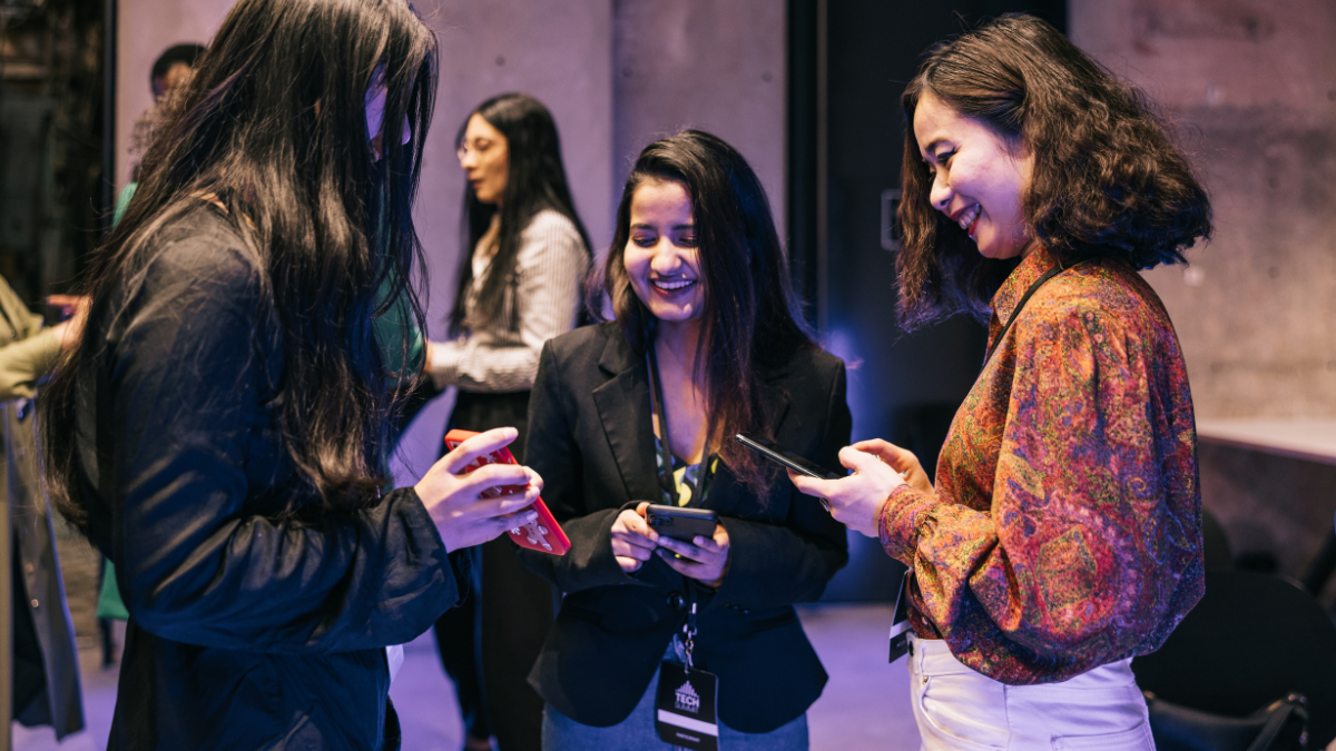 Event attendees using smartphones and engaging with digital content at a professional event, representing End-to-End AI Cloud Photography Solutions that connect on-site photography with instant digital experiences.