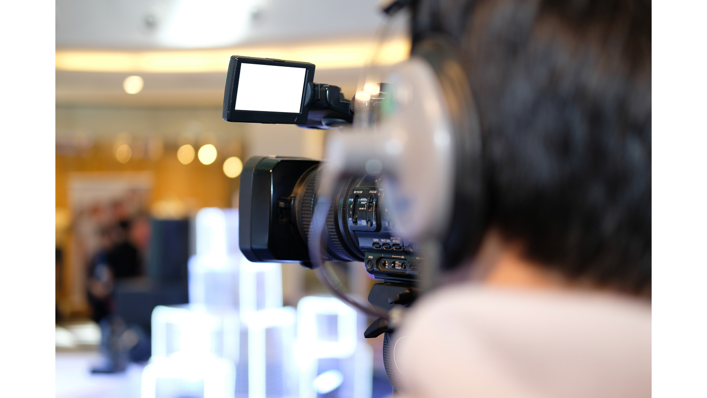 A professional videographer captures a live event using a high-end camera equipped with a monitoring screen. The setup illustrates Real-time AI Cloud Photography, where footage is instantly processed and uploaded to the cloud for immediate AI-enhanced editing and distribution