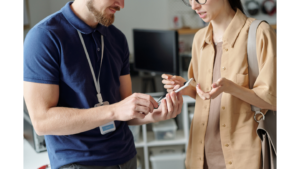 Event staff demonstrating the features of a mobile event app to an attendee on a smartphone.