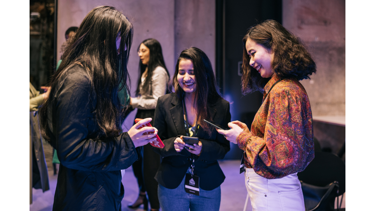 Conference attendees using mobile phones and event badges during registration process supported by instant badge printing at an international conference.