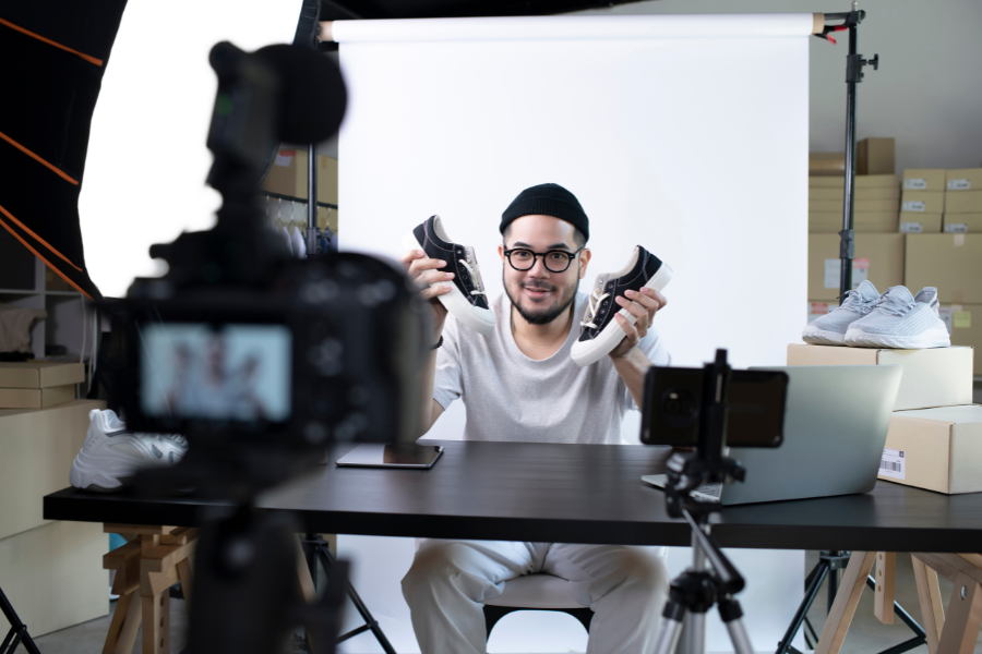Young attractive Asian man blogger or vlogger looking at camera reviewing product. Modern businessman using social media for marketing. Business online influencer on social media
