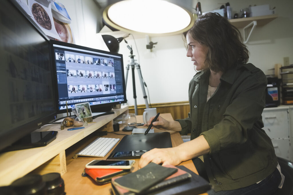 mid-adult-woman-sitting-at-desk-using-graphics-tablet