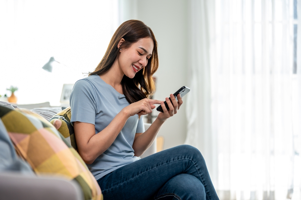 people scrolling phone in front of a Xiaohongshu sign